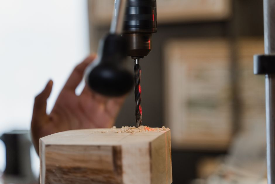 Close-up of a drill in action on wood, showcasing precise woodworking skills.