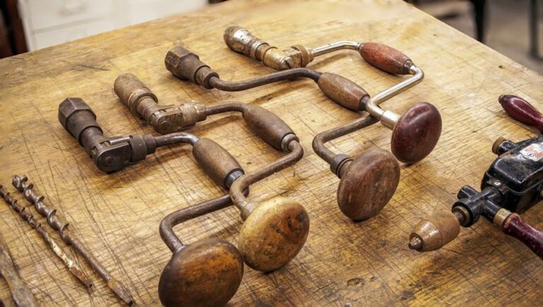 Collection of vintage hand drills with wooden handles on a rustic workbench.